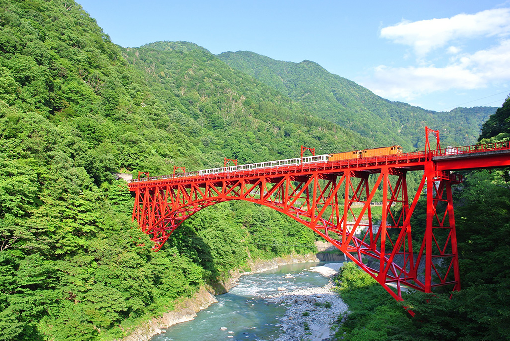 宇奈月駅からほど近い新山彦橋をわたるトロッコ電車（写真提供：黒部峡谷鉄道）